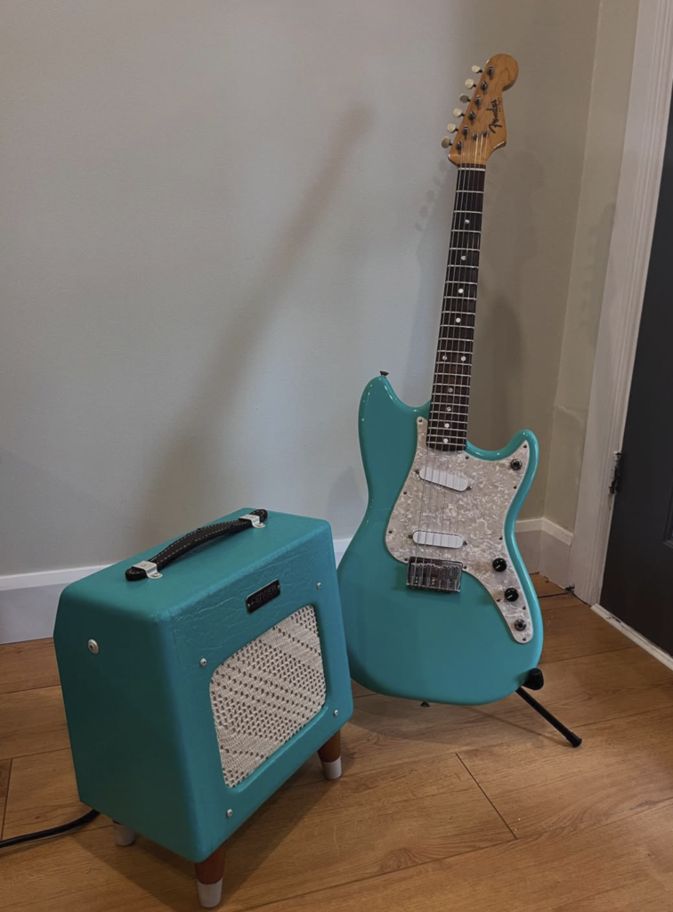 customized Fender Champion 600 teal with doily grille cloth and legs